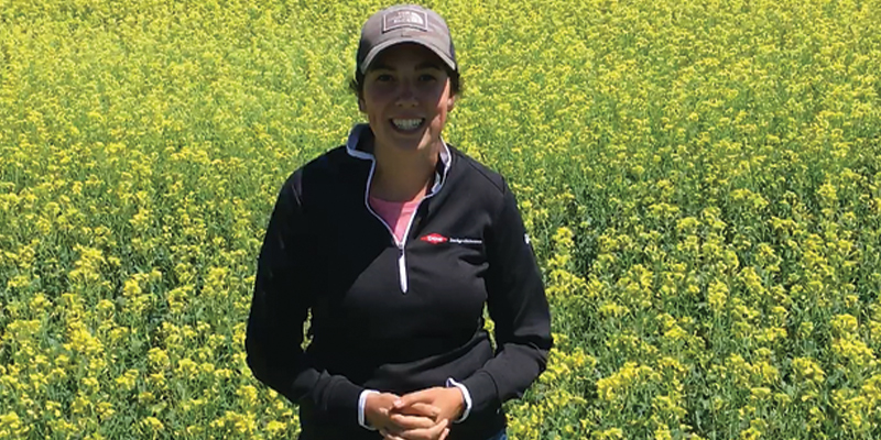 Woman standing in canola field about to give a presentation